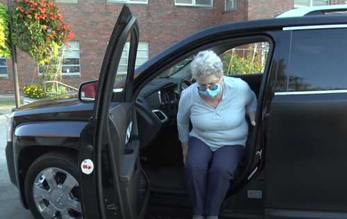 photo of older woman entering driver's side seat.